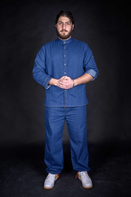 Man wearing high quality work clothes with personalized details. His work shirt has long sleeves that can be folded up to short sleeves too, supported by a metal bronze slide buckle.